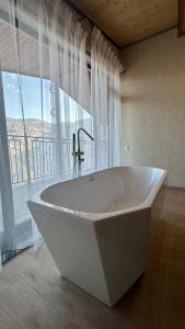 HalidzorHarsnadzor Eco Resort的带窗户的浴室内的白色大浴缸