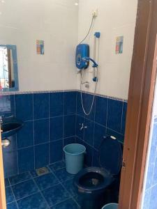 汝来Home in Nilai的蓝色瓷砖浴室设有卫生间和淋浴。