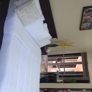 BacongVilla Estela guesthouse的一张带白色床单和枕头的床