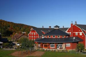 沃伦Clay Brook Hotel at Sugarbush的一座红色的大建筑,前面设有一个游乐场