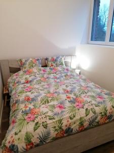 朗迪夫利耶Chez Stephanie的卧室内的一张床铺,配有花卉床罩