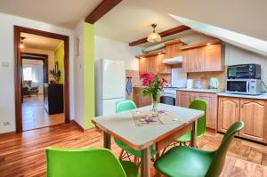 兰卡特Apartament przy Walowej的厨房配有桌子和绿色椅子