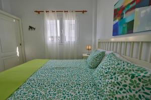 塔马达斯特Mar y Sol Casa Con Terraza y Barbacoa A 10 Metros del Mar的一间卧室配有一张带绿色棉被的床
