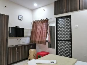 KukmaHotel Shiv Regency的客房设有床、电视和窗户。