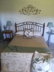 戈登湾Crossroads Guestrooms的一间卧室配有一张大床、两张桌子和两盏灯。
