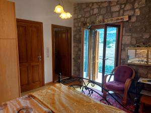 莱瓦贾Xenios Petritis的卧室配有床、椅子和窗户。