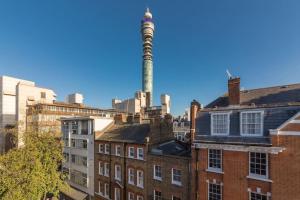 伦敦Stairway To Heaven - Fitzrovia - by Frankie Says的一座在建筑物顶部堆满烟雾的工厂