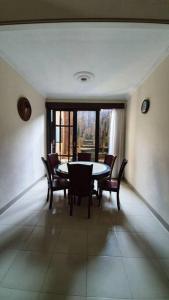 TanjungkarangVilla 5 BR utk Family/Grup di Villa Citra, Lampung的一间带桌椅和窗户的用餐室