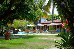 伊塔乌纳斯Pousada Estalagem Vila Tania的一个带椅子和遮阳伞的度假村和一个游泳池