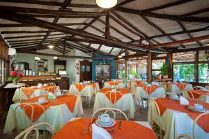 伊塔乌纳斯Pousada Estalagem Vila Tania的一间设有橙色和白色桌椅的餐厅