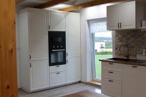 BernauFerienwohnung Stefanko的厨房配有白色橱柜、炉灶和窗户。