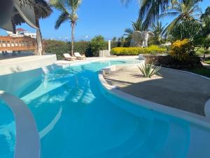 瓦塔穆Watamu Shell House的一座拥有蓝色海水和棕榈树的游泳池