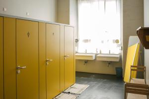 米兰卡萨贝斯青旅的浴室设有黄色橱柜、水槽和窗户。
