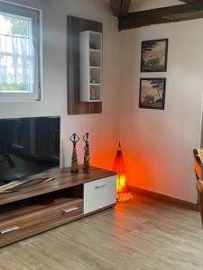 Hexenhüsli Waake的客厅配有平面电视和橙色墙壁。