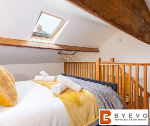 奥斯威斯ByEvo Oswestry Barn - Quirky romantic retreat or cosy contractor base的一间卧室配有带毛巾的床