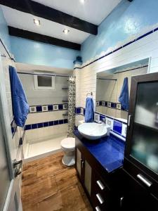 梅莱纳拉Bereli Beach的一间带水槽和卫生间的浴室以及一台电视。