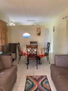基督教堂市Sasha’s Holiday Home Oistins Barbados的客厅配有桌椅和沙发