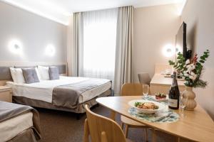 利沃夫Nota Bene Hotel & Restaurant的酒店客房,配有一张床和一张桌子,还有一碗食物
