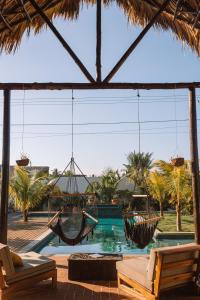 El Paredón Buena VistaCasa Zala的一个带吊床的庭院和一个种有棕榈树的游泳池