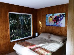 卡斯特鲁Cabañas Mirador Los Avellanos的一间卧室设有一张床和一个大窗户