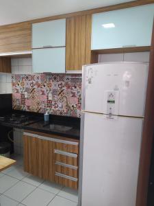 特雷西纳AP 201 Acolhedor situado na Zona Leste, com 3 quartos sendo 1 suíte的厨房配有白色冰箱和炉灶。