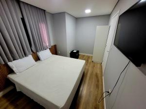 巴拉奈里奥-坎布里乌Pousada Al Mare的一间小卧室,配有一张床和一台平面电视