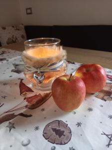 斯卢德尔诺Pferdehof Ansteingut的两只苹果坐在桌子上,带蜡烛