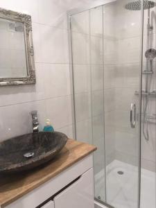 苏瓦乌基Apartament Centrum的一间带水槽和玻璃淋浴的浴室