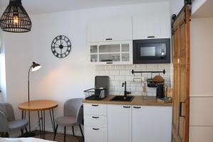 沃尔加斯特Hafenkoje Zum Anker的厨房配有白色橱柜和桌椅