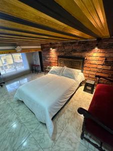 马尼萨莱斯Habitación con baño privado en aparthotel的一间卧室设有一张大床和砖墙