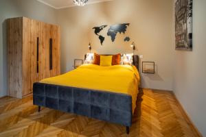 米什科尔茨Belvárosi apartman 'Bronze'的卧室配有一张大黄床,墙上有地图