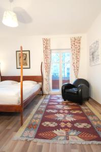 柏林斯塔维拉公寓的一间卧室配有一张床、一把椅子和地毯