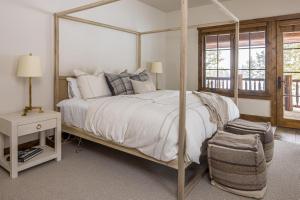 大天空市Western Tanager Cabin的一间卧室配有一张天蓬床和一把椅子