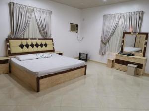 欧拉Almazham holiday house的一间卧室配有一张大床和镜子