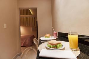 圣保罗Intense Motel的一张桌子,上面放着两个三明治和一杯橙汁
