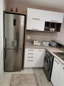 斯利文Markoni的厨房配有不锈钢冰箱和白色橱柜