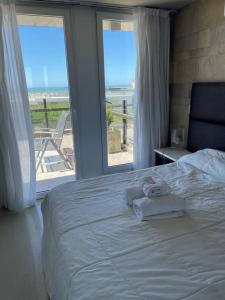 马德拉潘帕斯Linda Bay Premium Resort的一间卧室配有一张床,享有海滩美景