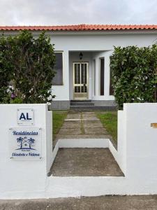 奥尔塔Casa das Palmeiras - Res. of Elizabete and Fatima的前面有标志的白色房子