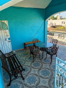 巴卡拉尔Casa Bonzay的阳台设有一张桌子和椅子,拥有蓝色的墙壁