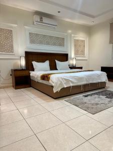 利雅德منازل المرجان للوحدات السكنية المفروشة Manzel Al Murjan Hotel Apartments的一间卧室设有一张大床和两个床头柜