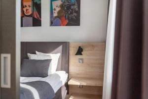 孔斯巴卡贝斯特韦斯特哈兰酒店的卧室配有一张墙上有两张照片的床。