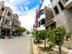 阿亚库乔Hotel Sol de Oro Ayacucho的一条空荡荡的城市街道,上面有酒店标志和树木