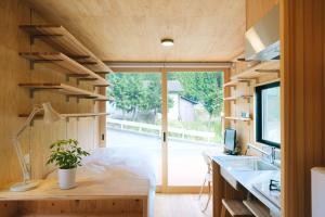 Nishiawakura安全第一客室 Anzen Daiichi INN的一个小房子,设有大窗户和一张书桌