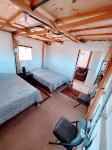 La casa de las sirenas Cabo pulmo的一间设有两张床和椅子的房间