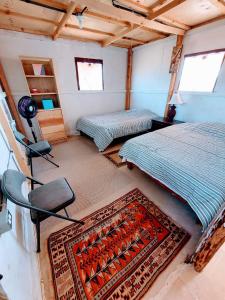 La casa de las sirenas Cabo pulmo的一间卧室配有两张床,房间铺有地毯