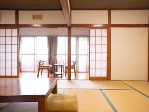 磐城美风之宿日式旅馆的客厅配有桌子和一些窗户