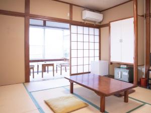 磐城美风之宿日式旅馆的客房设有桌子和带窗户的厨房