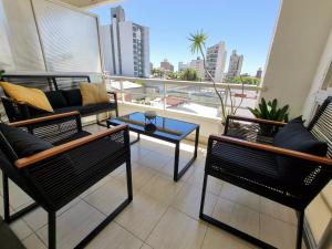 巴拉那Paraná Confort的阳台配有椅子、沙发和桌子