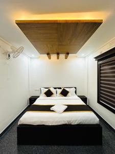 瓦亚纳德BEVERLY SUITES的一间卧室设有一张带木制天花板的大床