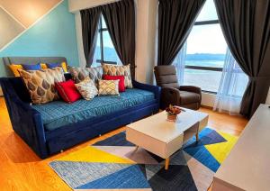 关丹Comfy Imperium Residence Kuantan Studio Seaview的客厅配有蓝色的沙发和桌子